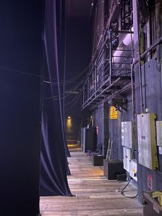 the inside of an industrial building with lots of pipes and wires on it's sides