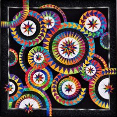 a colorful quilt with circles and stars on it