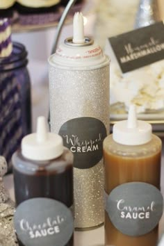 some condiments are sitting next to each other on a table with silver sequins