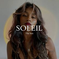 a woman with long brown hair wearing a black top and white lettering that reads soleil the sun