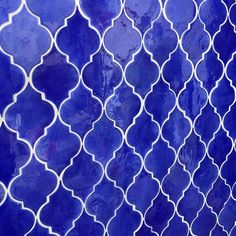 a close up view of a blue tile wall with white circles and lines on it