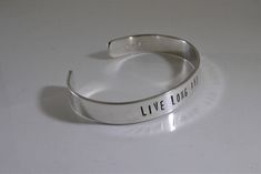 "For all the Trekkies out there! This bracelet is hand stamped with one of the most famous quotes. It says \"Live long and prosper.\" Have a different favorite quote?? You can make your own custom cuff here https://www.etsy.com/listing/157140397/custom-personalized-bracelet-38-1-line?ref=shop_home_active Shown in sterling silver but also available in the metal of your choice from the last photo. Solid gold options also available. Message me for pricing. Measures 3/8\" x 6\" and will fit most wri Silver Inspirational Cuff Bracelet, Inspirational Silver Cuff Bracelet, Inspirational Silver Cuff Bracelet Stamped, Inspirational Stamped Silver Cuff Bracelet, Minimalist Stamped Adjustable Cuff Bracelet, Adjustable Stamped Minimalist Cuff Bracelet, Meaningful Hand Stamped Cuff Bangle, Everyday Inspirational Personalized Cuff Bracelet, Personalized Inspirational Cuff Bracelet For Everyday