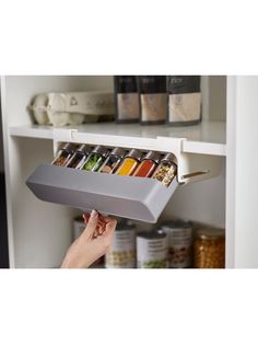 a person is holding a spice rack in their hand while she holds it up to the ceiling