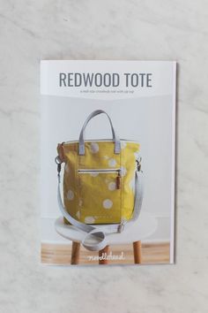 a book with a yellow polka dot bag on it's cover and the title redwood tote