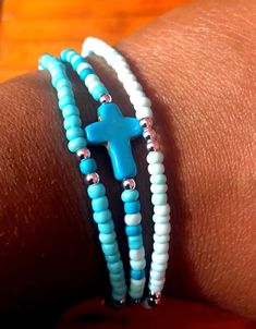 Handmade 3-piece turquoise, blue and silver plated seed beaded bracelets with blue colored cross bead (0.47 inch wide, 0.63 inch long, 0.16 inch thick). The seed beads are 3mm. Made with quality stretch cord.  Makes a great gift! Please measure your wrist before placing an order.  How to care for your bracelets:  Handle with care and please limit exposure to oils, water, fragrances, and chemicals.  See my other beautiful creations by visiting my store: https://karlaskreationz09.etsy.com Adjustable Light Blue Jewelry With Spacer Beads, Nickel Free Turquoise Beaded Bracelets As Gift, Nickel-free Turquoise Beaded Bracelets As Gift, Blue Wrap Bracelet With Tiny Beads For Gift, Nickel-free Turquoise Beaded Bracelet For Gift, Nickel-free Turquoise Beaded Bracelet Gift, Adjustable Turquoise Stretch Bracelet With Tiny Beads, Spiritual Turquoise Beaded Bracelets With Tiny Beads, Spiritual Turquoise Beaded Bracelet With Tiny Beads