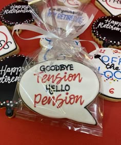 decorated cookies in the shape of speech bubbles on a red table with white and black lettering