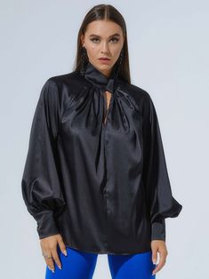 Polished femininity is a key detail in Tia Dorraine's designs, including this alluring blouse, crafted from a lustrous satin fabric in classic black. With an elegantly knotted, high neckline, oversized silhouette, and voluminous sleeves, this day-to-night design will remain a staple in your closet year after year.  Pair it with the Royal Azure Wide-Leg Trousers for an effortlessly elegant look. Hand wash only. Wash inside out with like colours. Do not wring or twist. Do not tumble dry. Iron at 1 Silk Long Sleeve Blouse For Evening, Luxury Long Sleeve Blouse For Evening, Sleek Solid Blouse For Night Out, Luxury Long Sleeve Evening Blouse, Luxury Satin Tops, Glamorous Evening Tops With Blouson Sleeves, Elegant Party Tops With Blouson Sleeves, Luxury Silk Tops For Night Out, Glamorous Silk Top For Formal Occasions