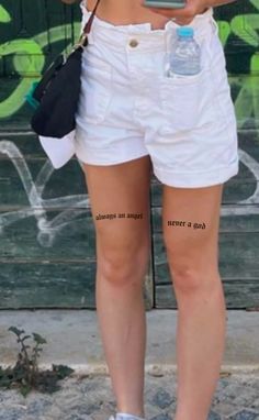 a woman in white shorts holding a cell phone and water bottle with writing on it