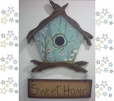 a birdhouse sign hanging from the side of a white wall with stars in the background