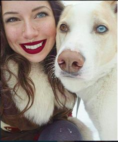 a woman with blue eyes and red lipstick hugging a white dog's face while the caption reads, heterorchoma - 2 different colored eyes