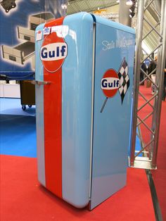 an old style refrigerator is on display at a convention or show in front of a blue and red carpet