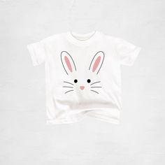 Custom handmade Bunny T-Shirt. Available in youth, toddler, and baby sizes. Perfect shirt for Easter and spring! H O W T O O R D E R Y O U R S H I R T : At checkout, please select the size you want, add to your cart, and then checkout through Etsy. If the size you want isn't in stock, I will message you right away and there will be a 2-3 day turn around time added to getting your shipment out. If you have a time deadline and want to check sizes on hand before you purchase, feel free to message m Family Matching White T-shirt With Cartoon Print, Unisex Cute T-shirt For Playtime, Funny Print T-shirt For Spring Playtime, Cute White T-shirt With Bunny Design, Spring Graphic Tee For Playtime, Spring Season Graphic Tee For Playtime, Playful Easter Short Sleeve T-shirt, Cute Shirt With Character Print For Playtime, Unisex Cute Short Sleeve Shirt