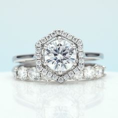 an engagement ring with a diamond center surrounded by three smaller round brilliant cut diamonds on each band