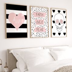 two posters on the wall above a bed in a room with white sheets and pillows