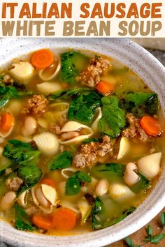 a bowl of italian sausage white bean soup with carrots, spinach and parsley