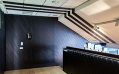 an empty bathroom with black walls and wood flooring on the wall is seen in this image