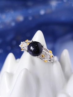 a close up of a ring on top of a white mountain with blue sky in the background