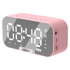 a pink alarm clock sitting on top of a table