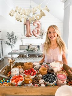 a woman standing in front of a table filled with food