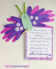 a purple and green paper butterfly with a note attached to it's back side