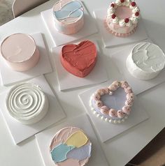 there are many different types of cakes on the white trays and one is heart shaped