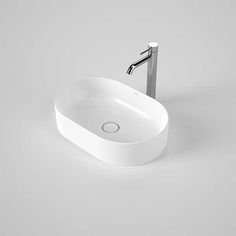 an oval shaped sink with chrome faucet