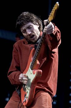 a man with an electric guitar on stage