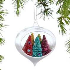 a christmas ornament hanging from a tree filled with small trees and ornaments on it's side