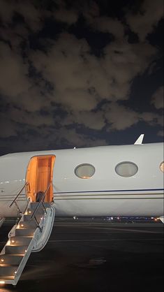 an airplane sitting on the tarmac with stairs leading up to it's door