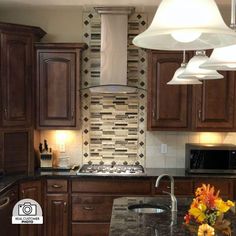 a kitchen with wooden cabinets and marble counter tops