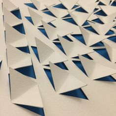 an abstract piece of paper with blue and white triangles on it's surface,