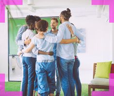 a group of people hugging each other in the middle of a room with pink and green walls