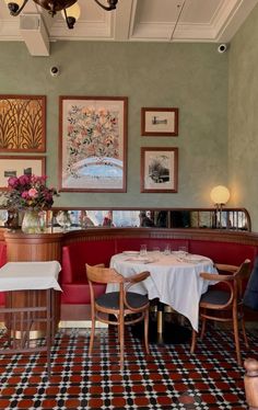 a dining room with tables and chairs in front of pictures on the wall above them