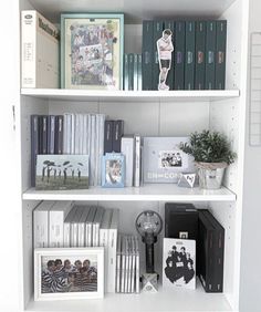 a white book shelf filled with books and pictures