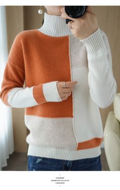 a woman is taking a selfie with her cell phone while wearing an orange and white sweater