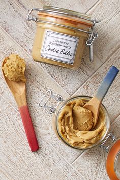 two jars of peanut butter and a wooden spoon