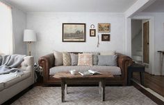 a living room with two couches, a coffee table and pictures on the wall