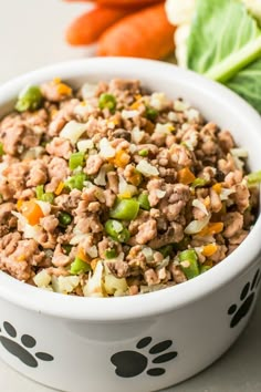 a close up of a bowl of food with carrots and lettuce on the side