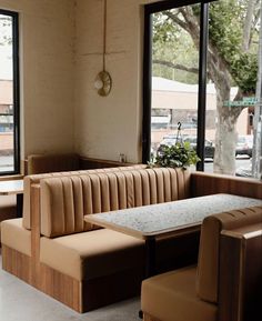 an empty restaurant with tables and chairs next to large windows that look out onto the street