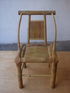 a chair made out of bamboo sitting on top of a wooden floor next to a wall