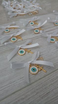 several pieces of white ribbon with blue and green eyes on them sitting on a wooden table