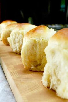 several pieces of bread sitting on top of a wooden cutting board