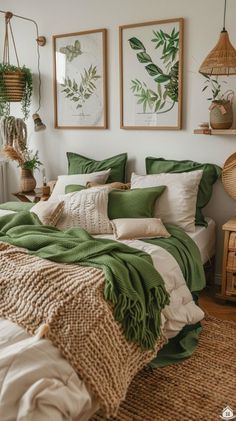 a bed covered in green and white pillows next to two pictures on the wall above it