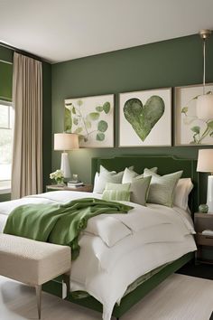 a green and white bedroom with pictures on the wall above the bed, along with a bench