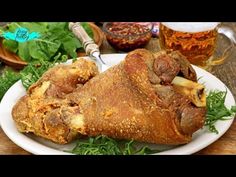 a large piece of meat sitting on top of a white plate next to some vegetables