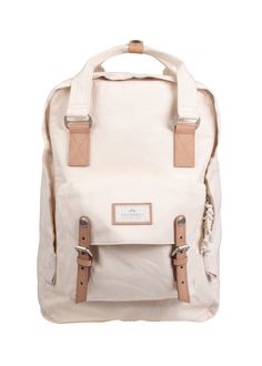 a white backpack with tan straps and two brown buckles on the front, sitting against a