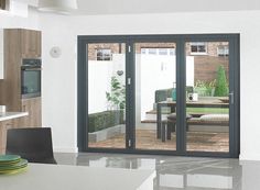 an open patio door leading to a dining room and kitchen area with outdoor furniture in the background