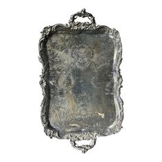 an antique silver tray with ornate designs on the edges and sides, set against a white background