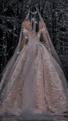 a woman in a wedding dress standing in the snow