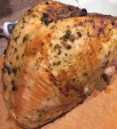 a cooked chicken sitting on top of a wooden cutting board